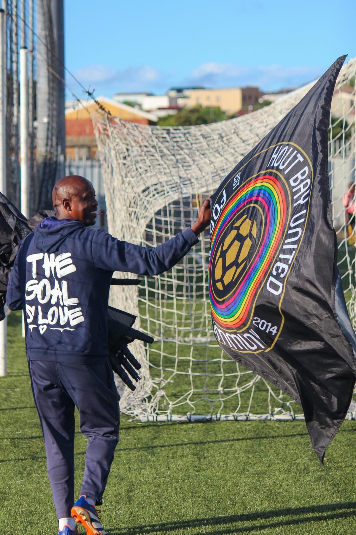 HBUFC coach with the club corner flag, crest and rainbow ring visible